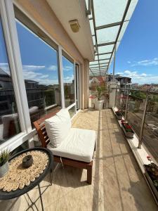 a balcony with a white couch and a table at Sunny Gym Studio Apartment in Burgas