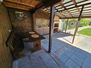 an outside patio with a wooden table in a building at Вила ДАР in Gara Oreshets