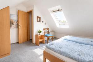 a bedroom with a bed and a window and a chair at Glaeßer Appartements in Burg auf Fehmarn