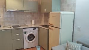 a kitchen with a refrigerator and a washing machine at Timón, cerca de la Playa in Candás +10 photos