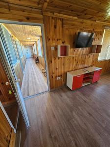 a living room with wooden walls and a tv and a desk at Вила ДАР in Gara Oreshets