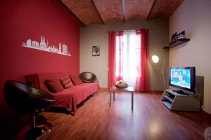 バルセロナにあるCharm Rambla Catalunyaのリビングルーム(赤いソファ、テレビ付)