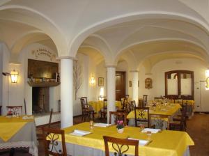 a restaurant with yellow tables and chairs and a fireplace at Villa Schiavi in Sermide