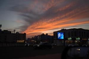 a sunset with cars driving down a city street at كيان الين الشبلان - KAYAN ALYN AlMansak Suites in Abha