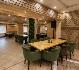 a dining room with a wooden table and green chairs at Prenociste Simke 2 in Subotica