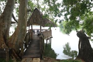 a wooden dock with a hut on the water at Aji fruit farm cottage peaceful lakeside farm stay with sunrise views 03 in Embilipitiya
