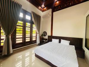 a bedroom with a white bed and a window at An Haven Villa in Phú Xá +15 photos