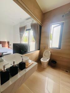 a bathroom with a tub and a toilet and a window at An Haven Villa in Phú Xá