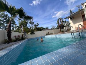 a swimming pool with two people in the water at An Haven Villa in Phú Xá