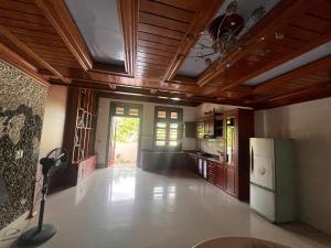 a large kitchen with wooden ceilings and a refrigerator at An Haven Villa in Phú Xá