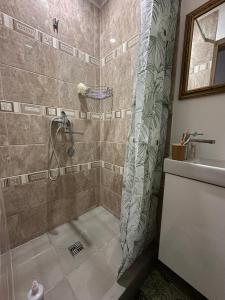 a shower with a shower curtain in a bathroom at Bruno māja in Strenči