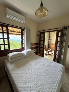 a bedroom with a white bed and a large window at A casa do vale in Bananeiras +25 photos