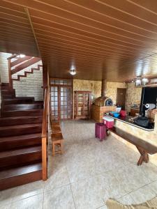 a living room with a staircase and a kitchen at A casa do vale in Bananeiras