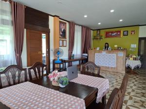 a dining room with a table with a laptop on it at สายป่าน เฮ้าส์ แพร่ in Ban San Pa Yae