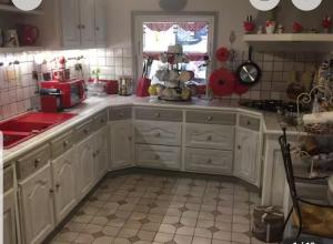 a kitchen with white cabinets and a window at Arlette Guest House in Essarts