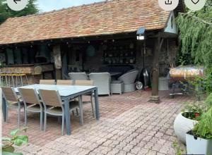 a patio with a table and chairs in front of a building at Arlette Guest House in Essarts