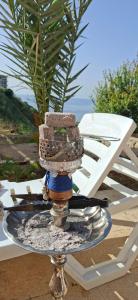 a glass plate with a fountain on a table next to a chair at Honey Chalet in Al Khayyām