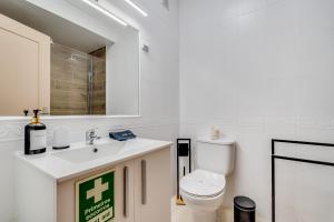 a bathroom with a white toilet and a sink at Albufeira prime stay in Albufeira +16 photos