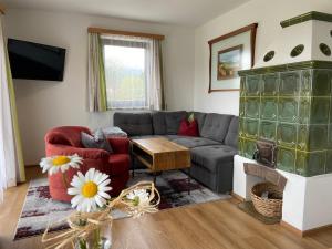 a living room with a couch and a fireplace at Das Sunnhäusl in Mariapfarr