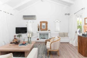 a living room with a table and a fireplace at Villa NS in Perdika