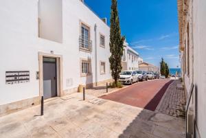 a street in a villa with cars parked on the road at Albufeira prime stay in Albufeira