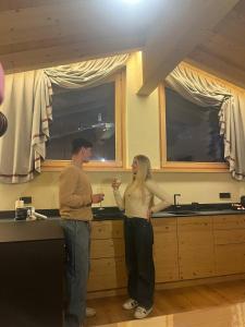 a man and a woman standing in a kitchen at Mot chalet in Valdidentro