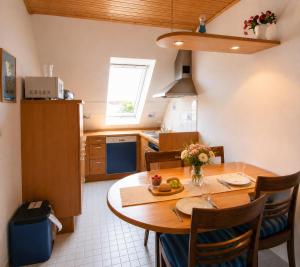 a kitchen with a wooden table and a dining room at Glaeßer Appartements in Burg auf Fehmarn