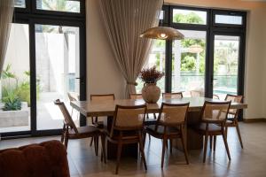a dining room with a wooden table and chairs at Bustan Alsafia بستان الصافية in Nizwa