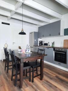 a kitchen with a wooden dining table and chairs at Gemütliche Ferienwohnung Traumfänger NOK in Schafstedt