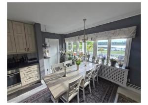 a kitchen with a long table with chairs and a window at Kulla Gard in Ingarö