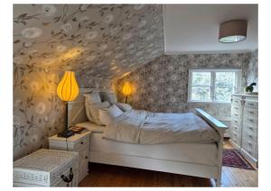 a bedroom with a bed and a wall with flowers at Kulla Gard in Ingarö