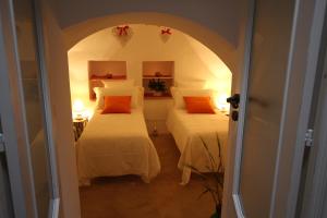 アルベロベッロにあるSuite del Vicoのベッド2台とアーチ型の出入口が備わる客室です。