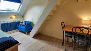 a living room with a blue chair and a table at B&B De Schorre in Boom
