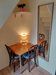 a dining room table with chairs and a mirror at B&B De Schorre in Boom