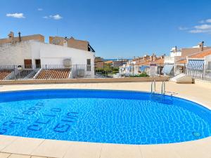 a large blue swimming pool in front of a building at Penthouse with Panoramic View Santa Pola in Santa Pola