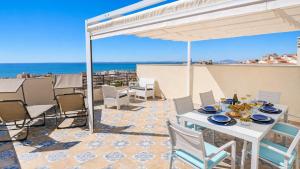 a patio with a table and chairs and the ocean at Penthouse with Panoramic View Santa Pola in Santa Pola +17 photos