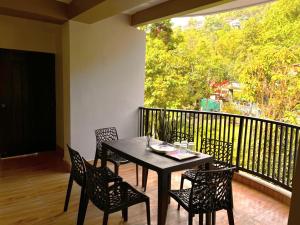 a black table and chairs on a balcony with a window at Happy Homestay Sittong in Mangpu