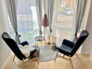 a living room with two chairs and a table and a window at Nida in Nida