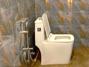 a white toilet in a bathroom with a wall at Happy Homestay Sittong in Mangpu