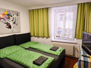 a bedroom with a green bed and a window at Altstadthaus Marille mit Innenhofterrasse in Melk