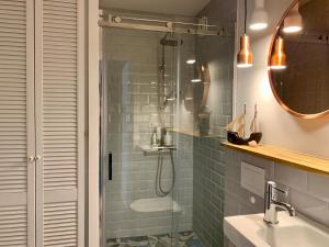 a bathroom with a shower and a sink and mirror at Nida in Nida +5 photos