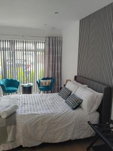 a bedroom with a bed and two blue chairs at The Snug on The Brae in Inverness