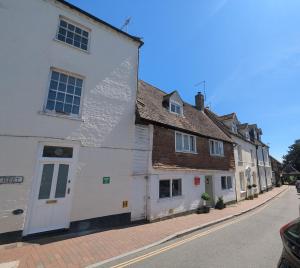 an old white building on the side of a street at Historic maisonette cottage in Cuckfield