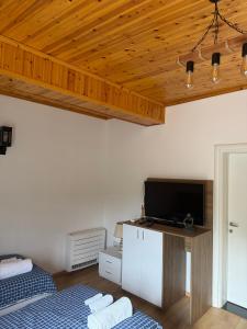 a room with two beds and a flat screen tv at Bujtina Lugina e vjosës in Përmet