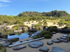 a garden with rocks and a pond at Nature Resort in Kawamoto in Kawamoto