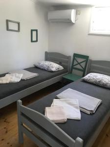two beds in a room with two chairs and towels at Femyli rooms in Shekhvetili