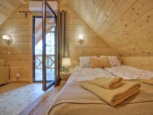a bedroom with a large bed in a wooden house at Na Las Czas in Sompolno