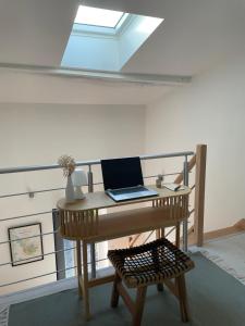 a laptop computer sitting on a desk in a room at L'entre deux M in Saint-Loubès