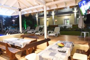 a patio with tables and chairs and a television at Laida studios in Prinos +179 photos