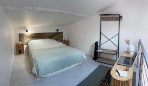a bedroom with a bed and a desk with a laptop at L'entre deux M in Saint-Loubès +38 photos